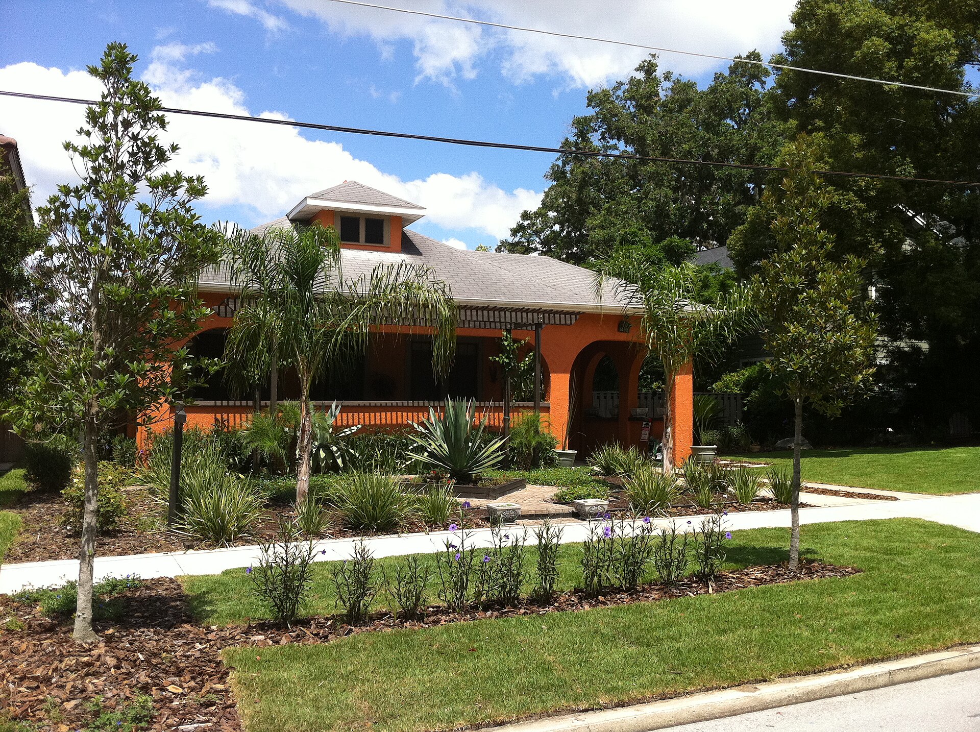 Orange stucco 1930s bungalow with landscaped yard in Orlando's College Park